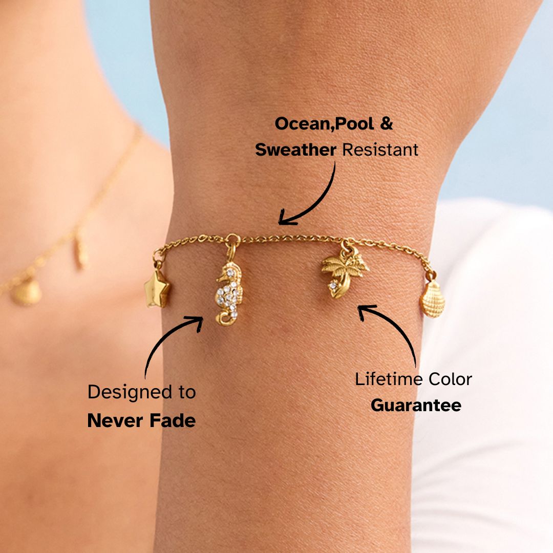 Female model wearing ocean-themed gold bracelet with crystal seahorse and palm tree.