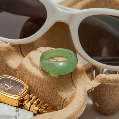 Close-up of green retro resin ring with sunglasses and watch