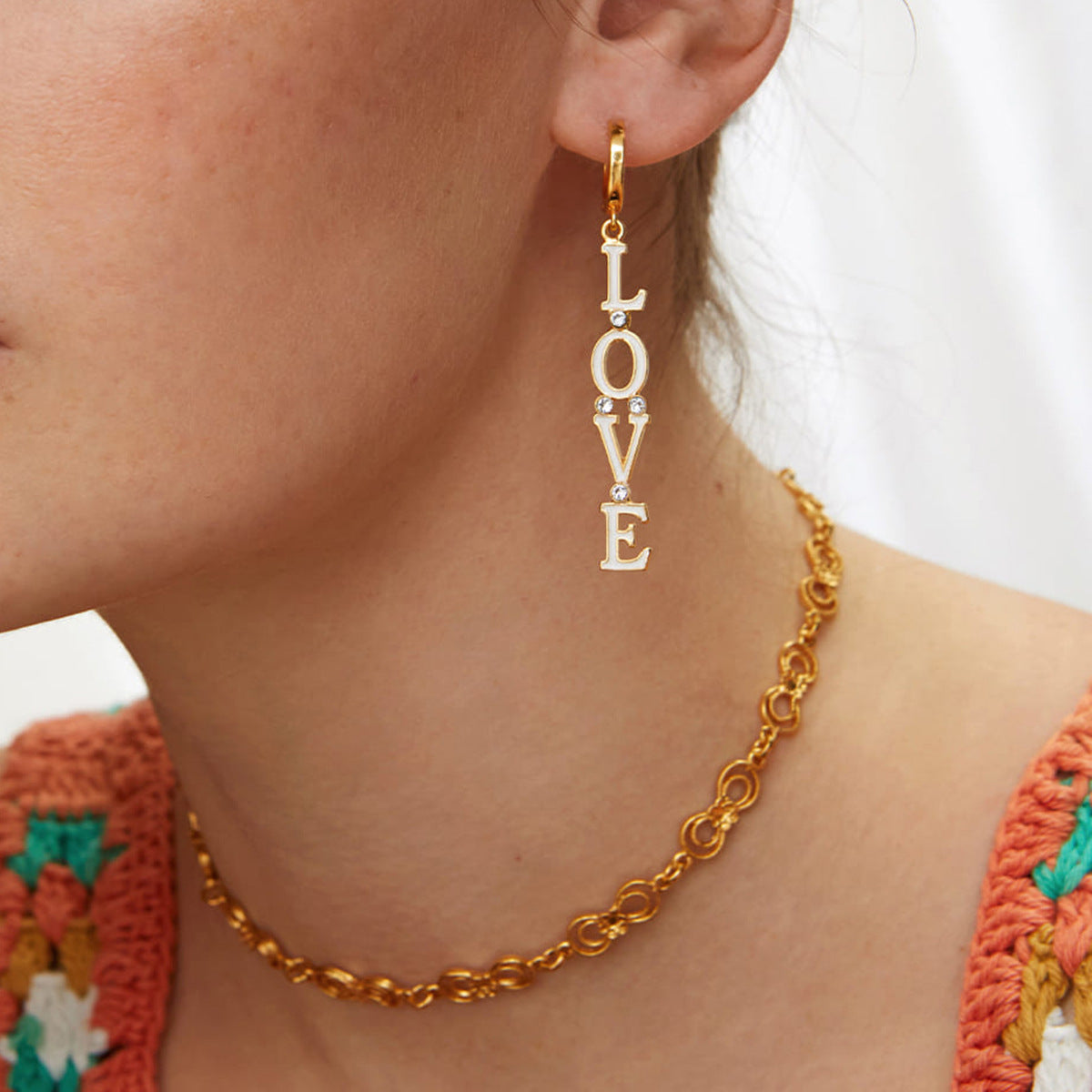 Model wearing golden LOVE earrings, perfect for a flirty daytime look_MiFJewelry
