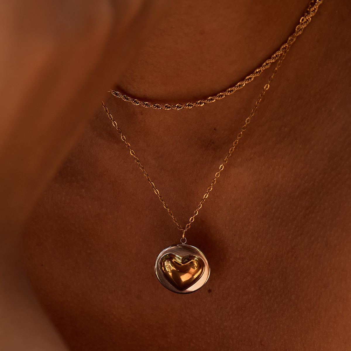 Close-up of heart-shaped pendant necklace worn by woman in summer dress, golden sunlight