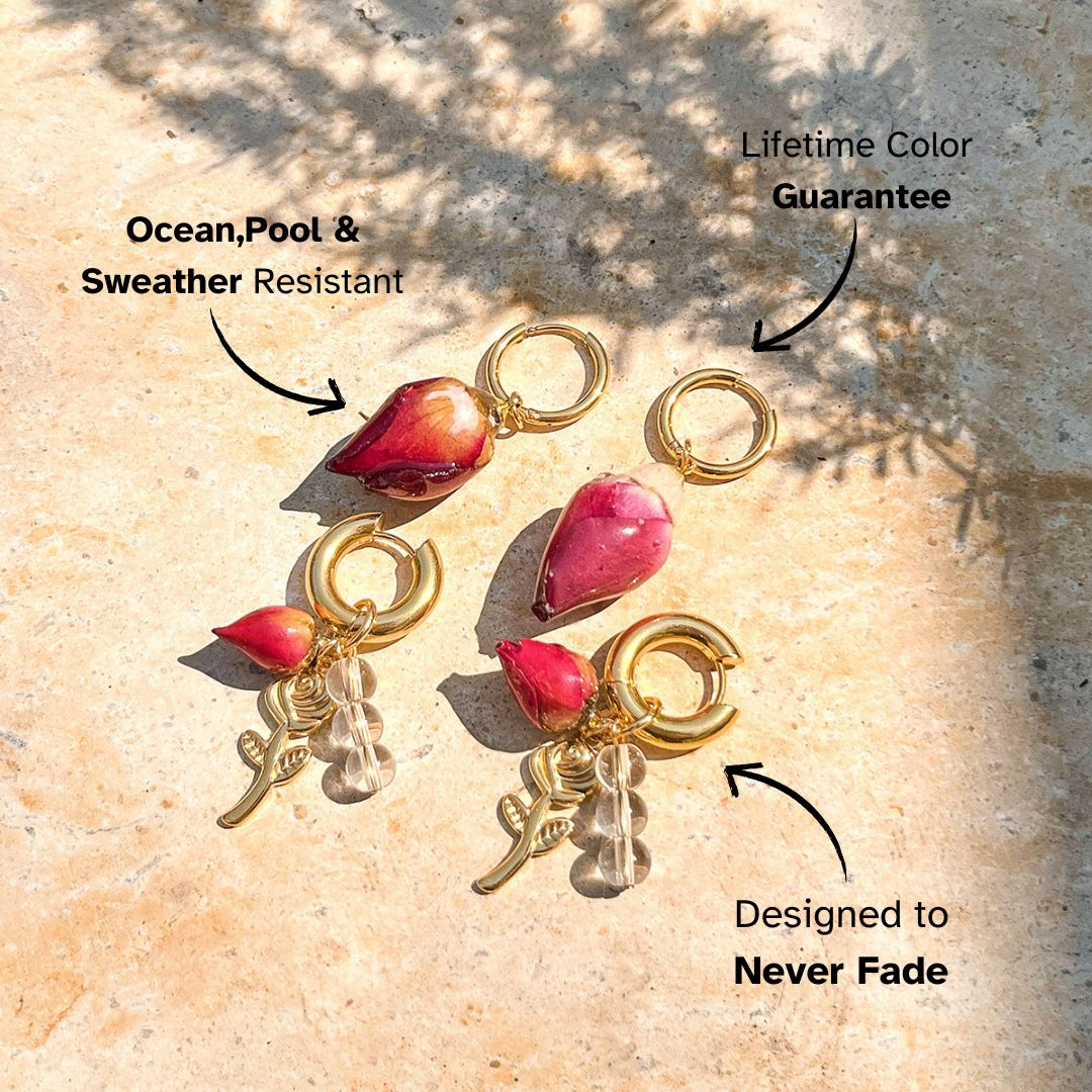 Set of gold earrings with preserved rosebud drops and charms