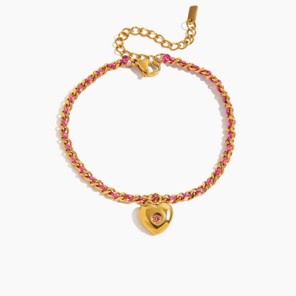 Gold bracelet with pink stones and a heart-shaped clasp on a white background