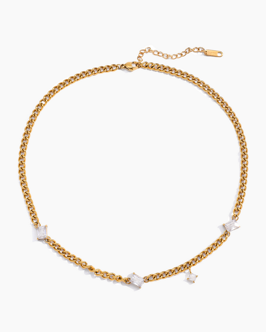 Gold chain necklace with small white stones on a white background