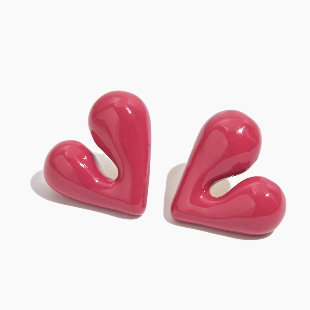 Pair of pink heart-shaped earrings on a white background