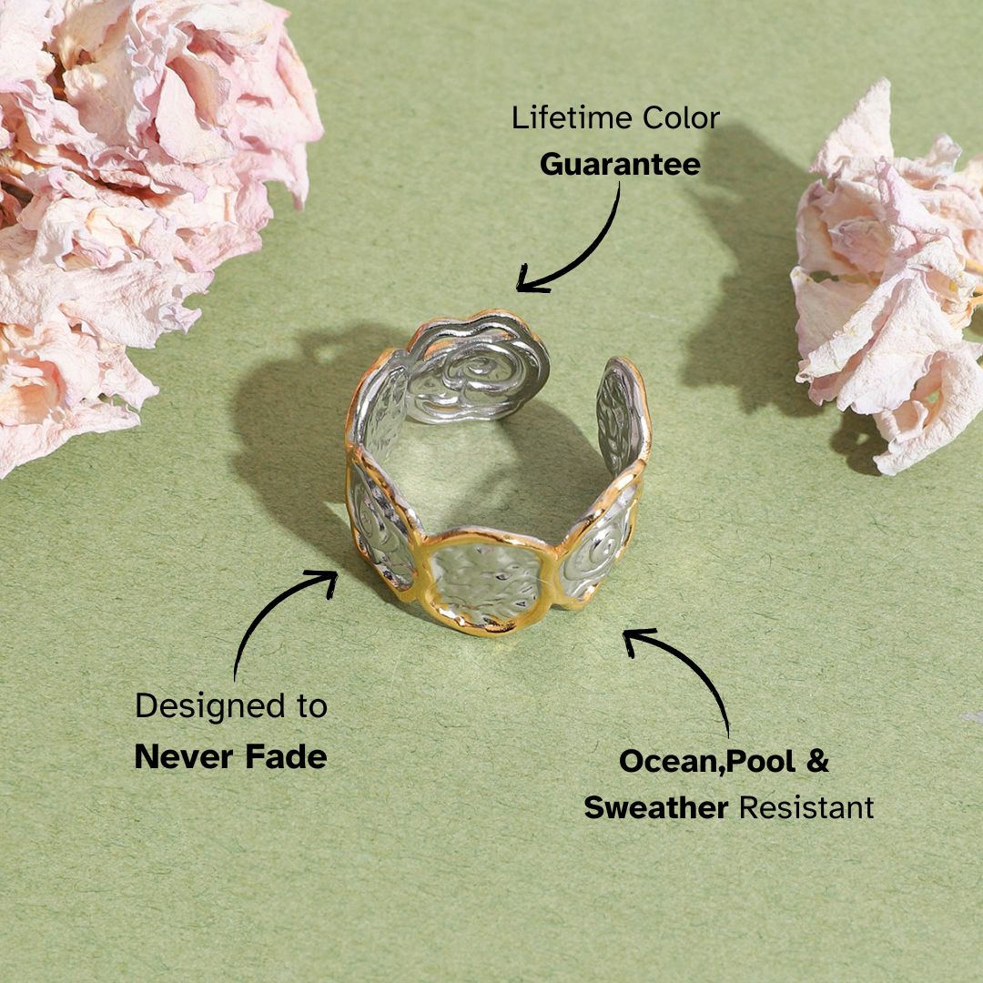 Gold and silver sculpted heart ring with abstract swirls on green backdrop