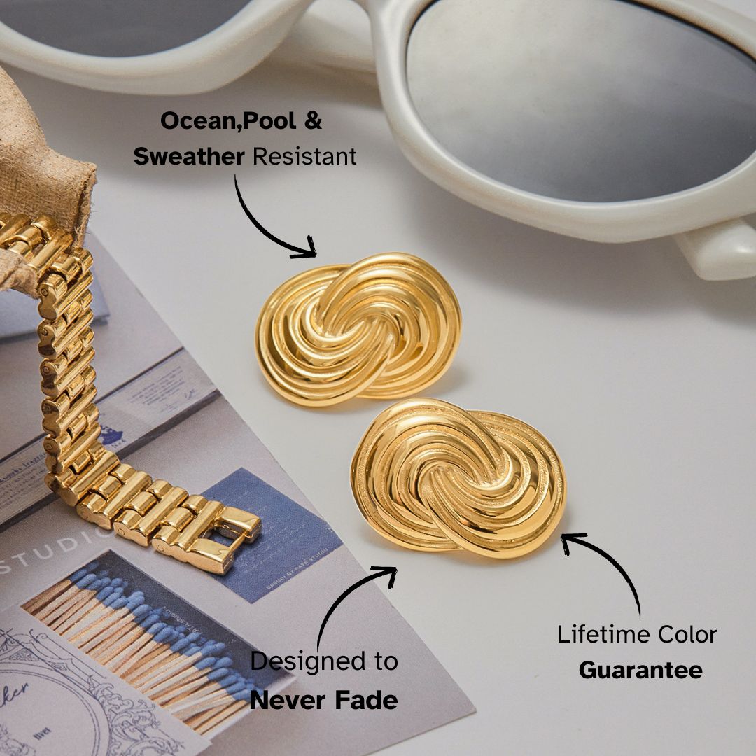 Golden spiral texture earrings photographed next to sunglasses