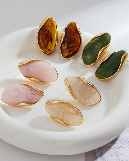 Set of colorful stone rings with gold accents on a white plate.