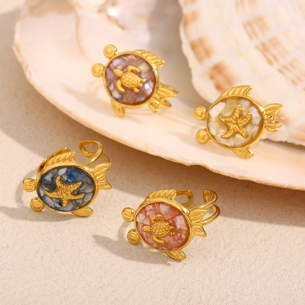 Close-up of five adjustable shell rings featuring turtles and starfish on neutral background