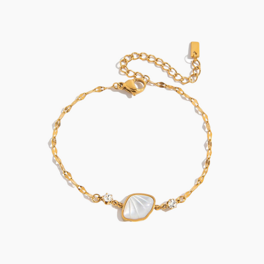 Gold bracelet with a heart-shaped white stone on a white background