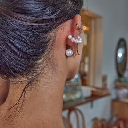 Back view of double-sided earrings featuring pearls and open star shapes