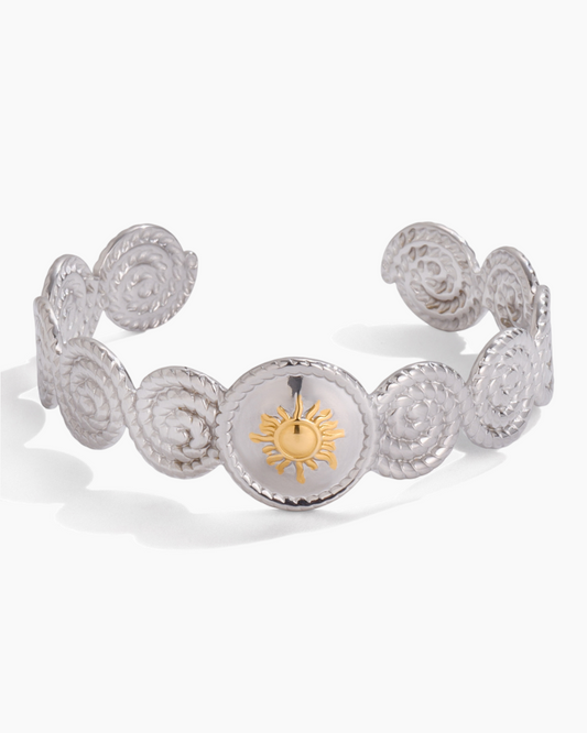 Silver bracelet with a sun emblem on a white background