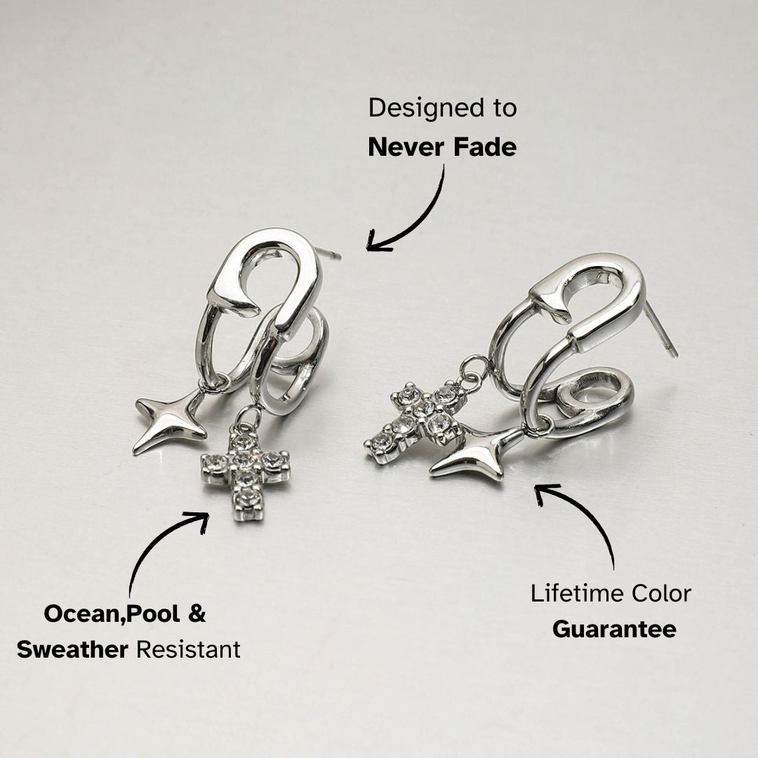 Product image of silver safety pin earrings with cross and star charms