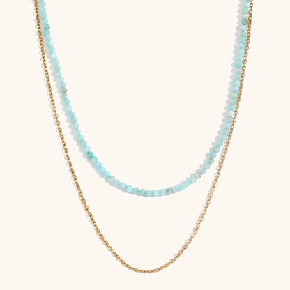 Pastel blue layered crystal necklace with shimmering gold chain detail
