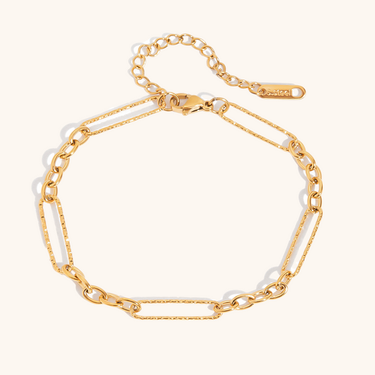 Close-up of sleek gold link chain bracelet on white background.