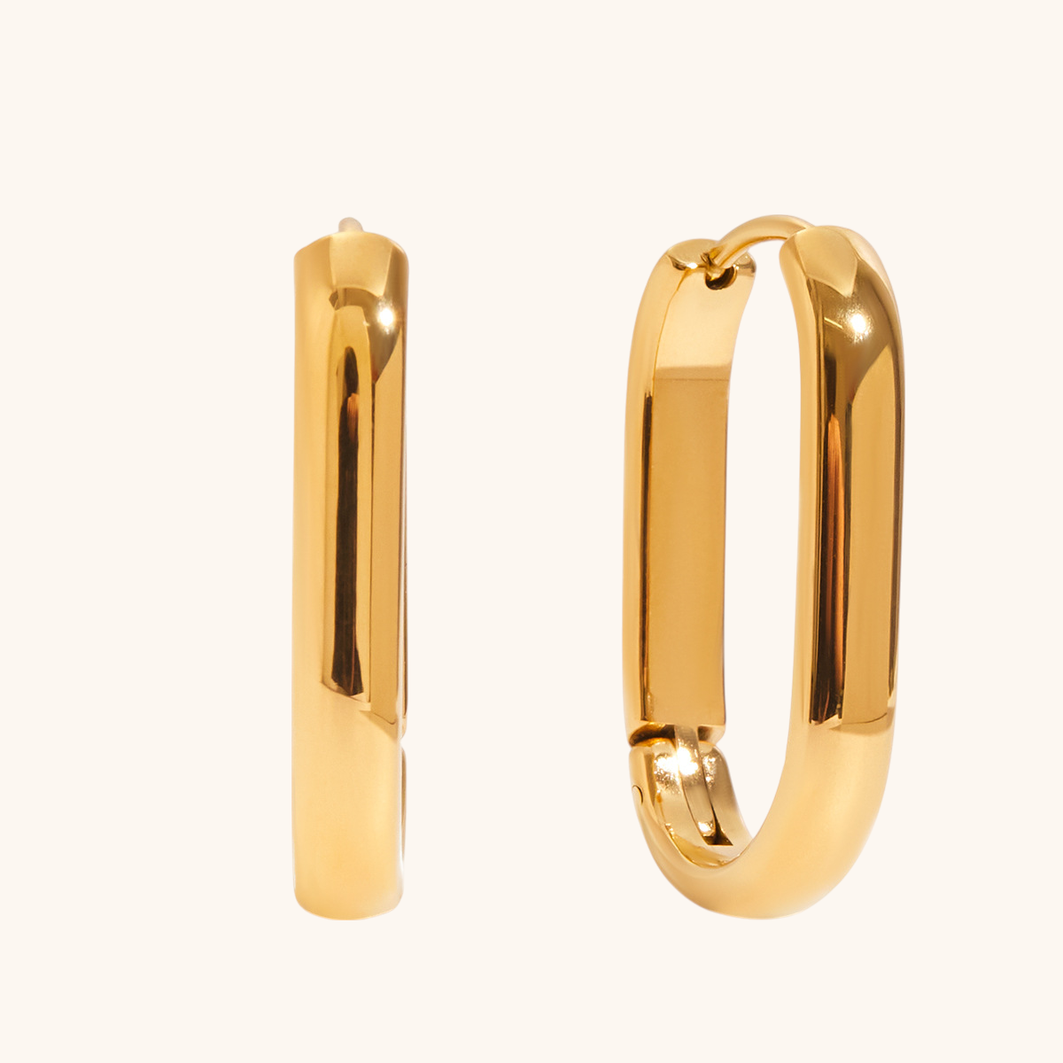 Close-up of waterproof gold hoop earrings on beige background