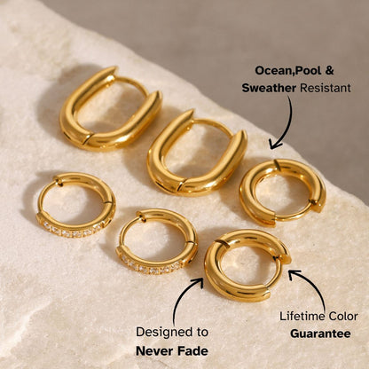 Small smooth gold round hoops on beige stone background