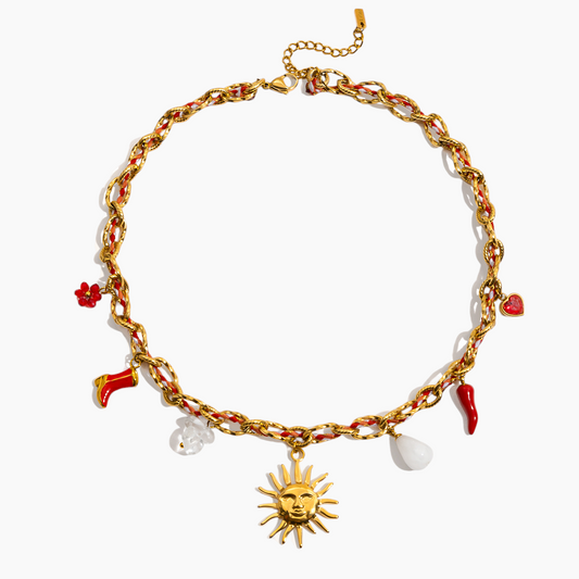 Gold chain bracelet with various charms on a white background