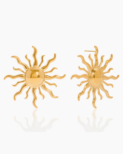 Gold sun-shaped earrings on a white background