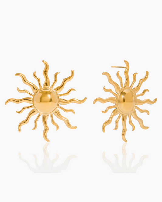 Gold sun-shaped earrings on a white background