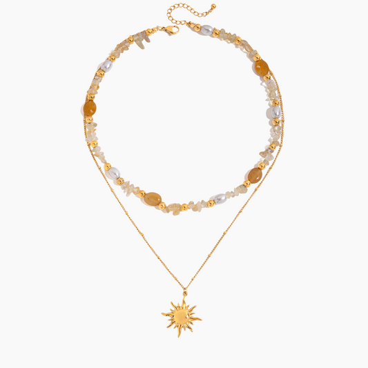 Two layered necklaces with sun pendant and beaded chain on a white background