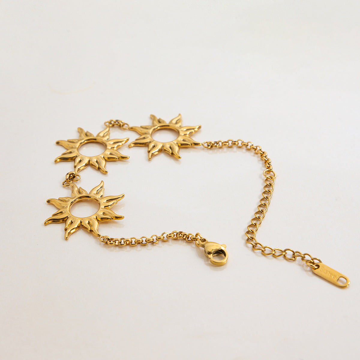 Detail image of gold sun bracelet chain with secure clasp and sun cutouts