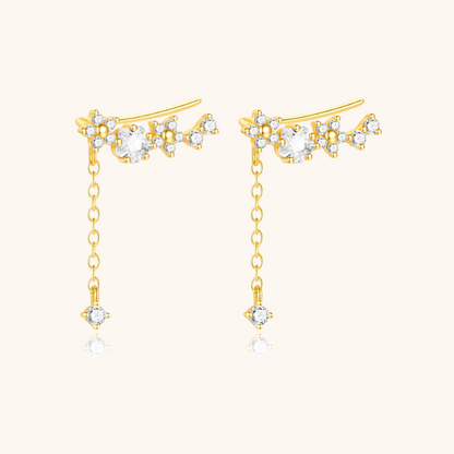Zircon flower ear climber with hanging crystal, shown from different angle in warm light.