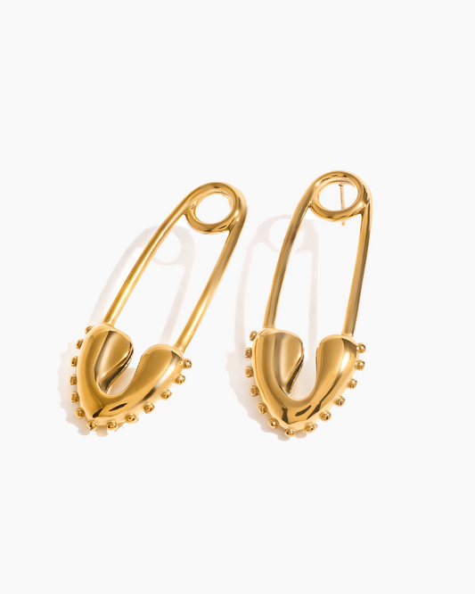 Gold safety pin earrings on a white background