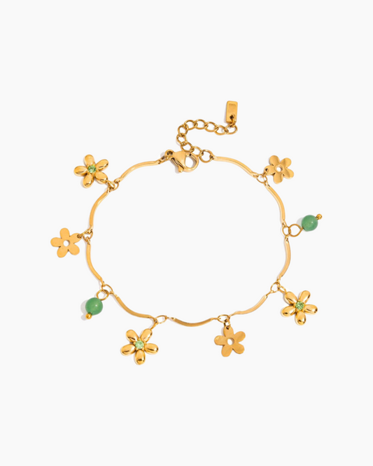 Gold bracelet with flower-shaped charms on a white background