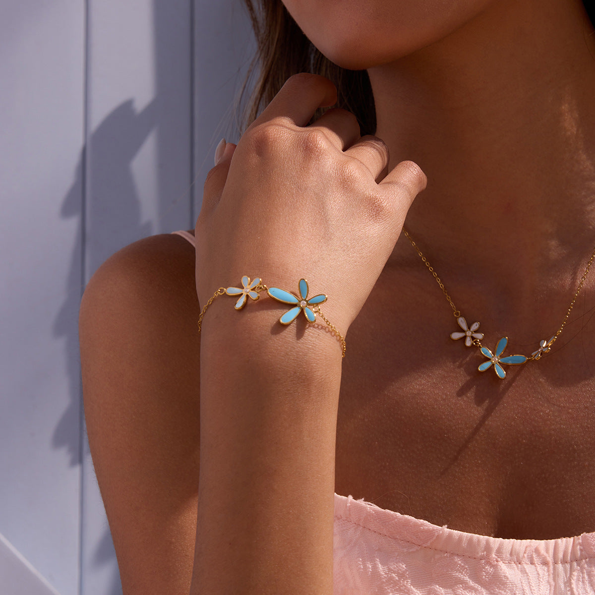 Close-up of delicate floral enamel bracelet worn with matching necklace