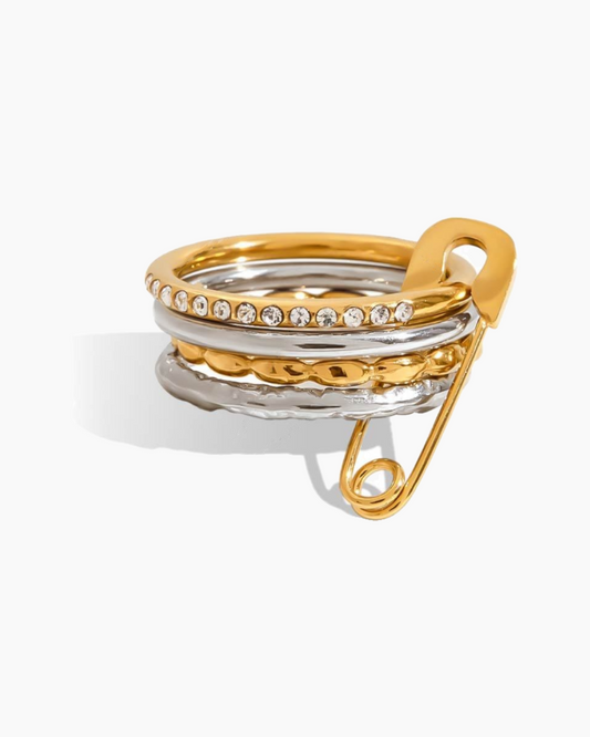 Gold and silver ring with embedded crystals on a white background