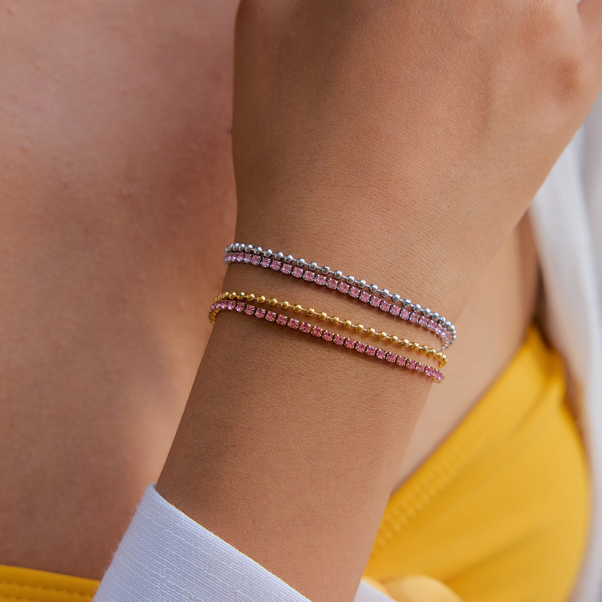 Three beaded pink bracelets styled on wrist with summer outfit
