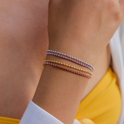 Three beaded pink bracelets styled on wrist with summer outfit
