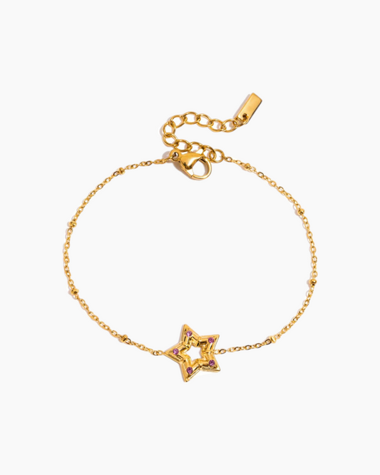 Gold bracelet with a star-shaped charm on a white background