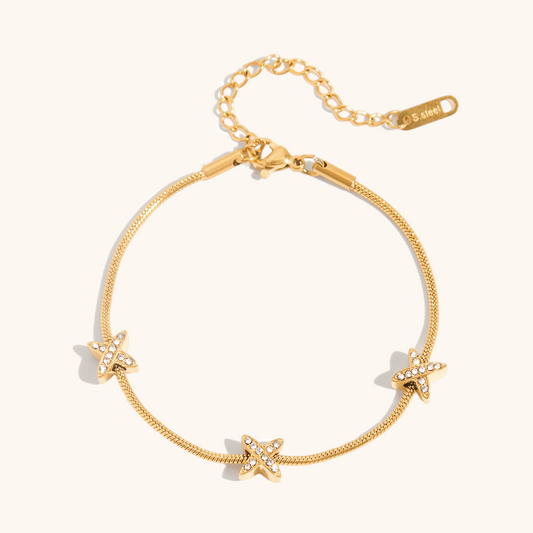 Gold star charm on delicate chain against a clean backdrop.