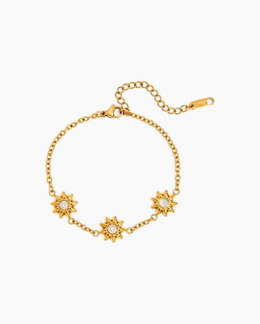 Gold bracelet with star-shaped ends on a white background