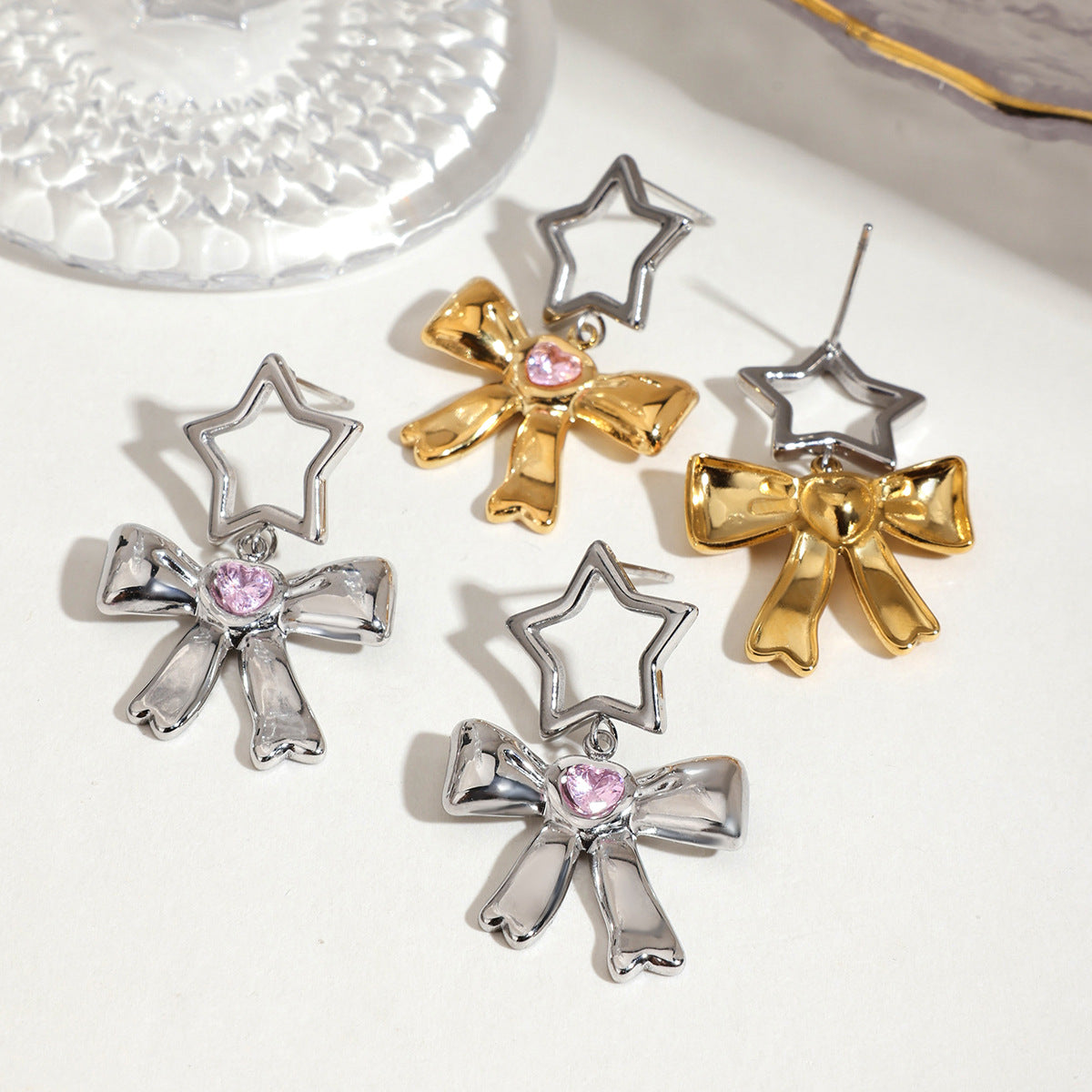 Mixed gold and silver bow drop earrings with pink gemstone hearts