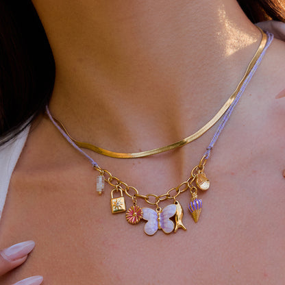 Whimsical gold charm necklace with purple thread cord