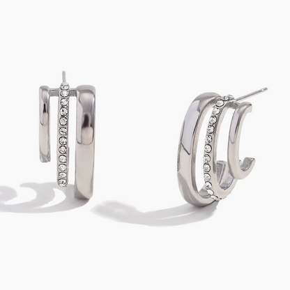 Silver hoop earrings with embedded stones on a white background