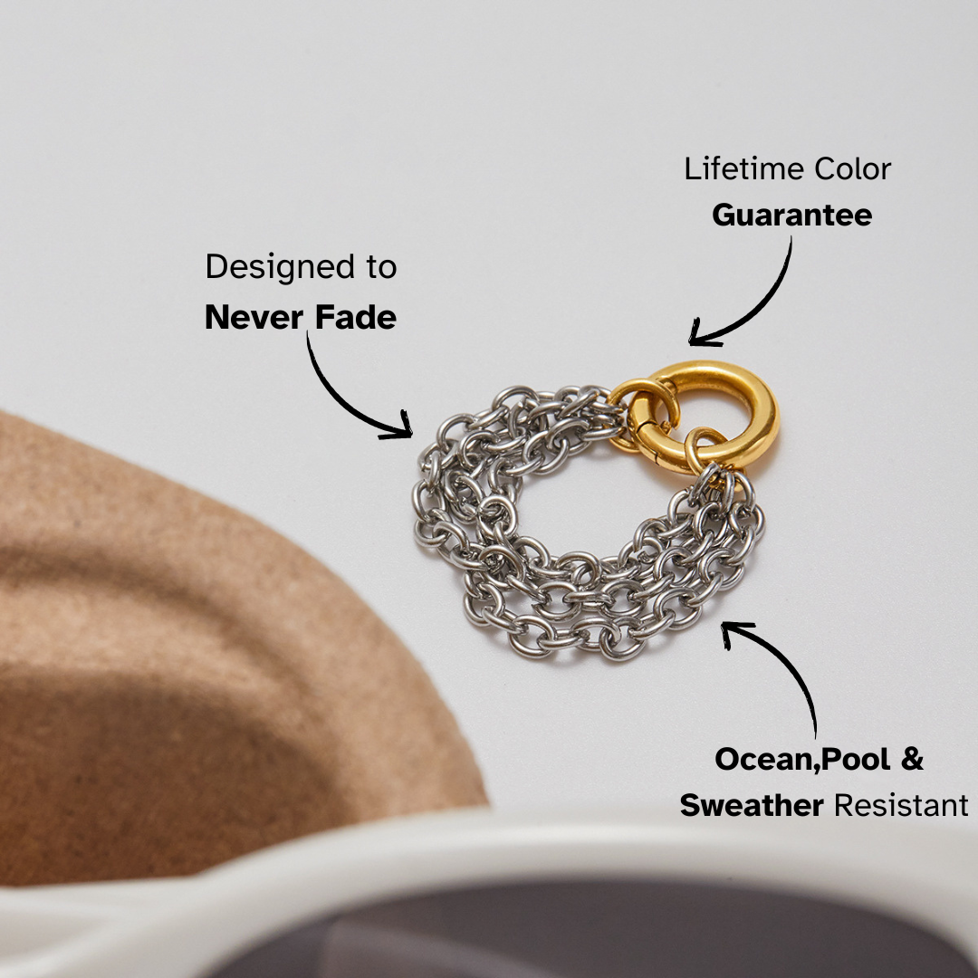 Silver chain ring with gold accent styled next to sunglasses