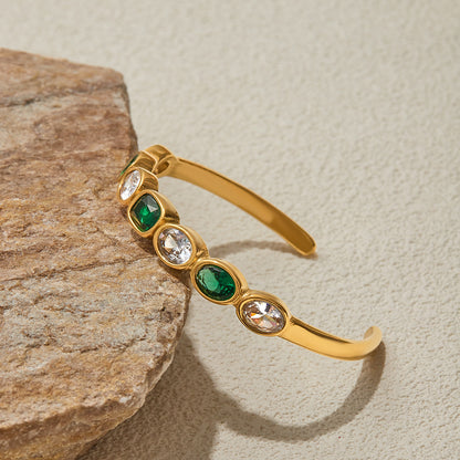 Close-up of gold bracelet with alternating green and clear stones for daily glam.