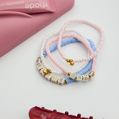 Close-up of cute waterproof letter bracelets on pink background