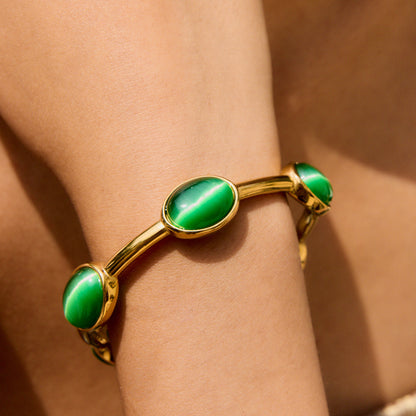 Woman wearing green stone bangle at the beach in close-up shot