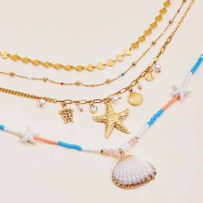 Close-up of white, blue and coral beaded necklace with seashell pendant