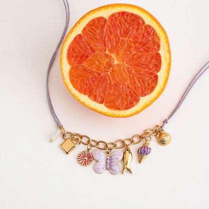 Enamel charm necklace styled with orange slice