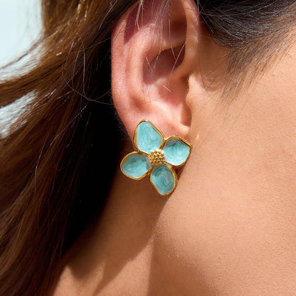 Model wearing mint green enamel flower earrings in the sun