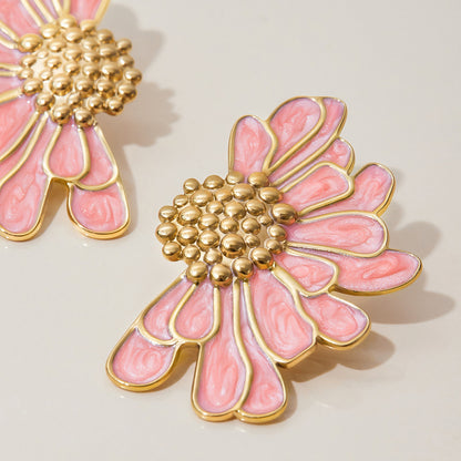Close-up of pink floral stud earrings with gold bead center