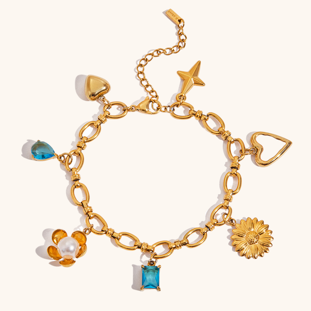 Close-up of waterproof gold bracelet with daisy, heart and star pendants
