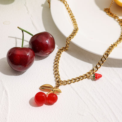 Cherry and strawberry pendant necklace with fresh cherries on a white plate