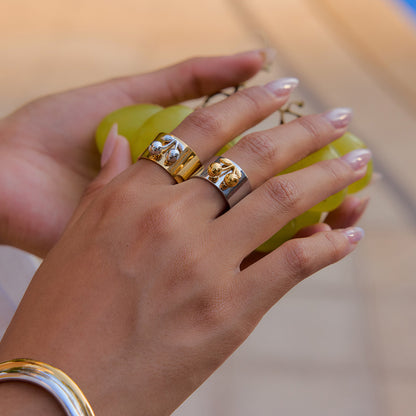 Close-up of silver band cherry ring on model's finger with grapes