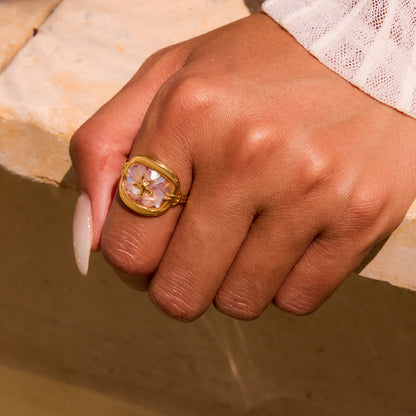 Stylish hand shot of gold starfish ring paired with white summer outfit